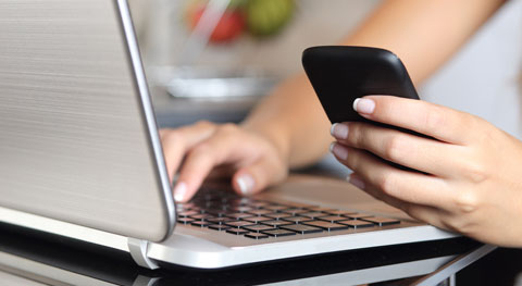 Girl using a laptop and smart phone